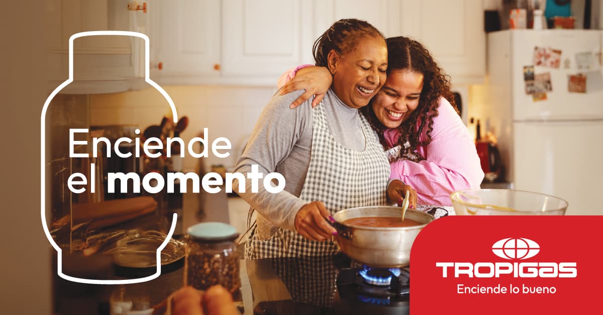 Enciende el momento. Tropigas: una madre y su hija cocinan abrazadas en la cocina de su casa.
